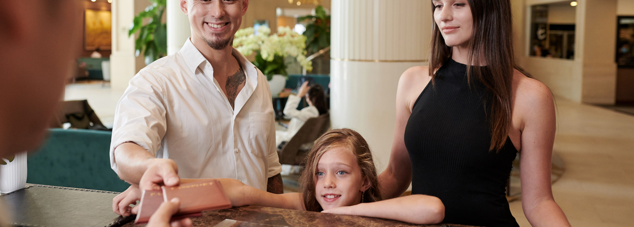 Gezin checkt in met paspoort bij een hotel