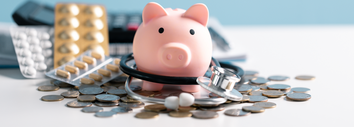 Prinsjesdag; spaarvarken met stethoscoop muntgeld, pillen en een rekenmachine op een blauwe achtergrond